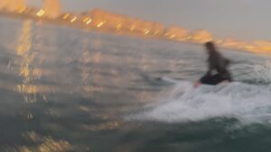 Surfer riding a wave on a sunny day.